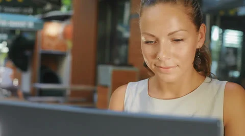 An attractive woman sitting in a cafe and working on the computer Stock Footage