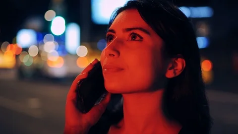 Attractive woman smiling when using smartphone on street. Night city lights Stock Footage 93789326