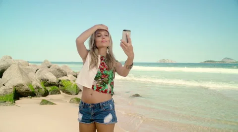 Attractive woman taking a selfie on smartphone at Ipanema beach Stock Footage 59376247
