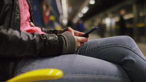 Attractive woman at a train station using her smart phone, in slow motion Stock Footage 61013000