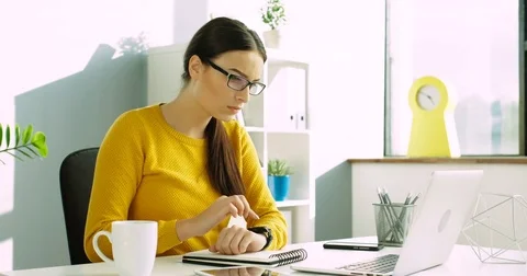 Attractive woman using her smart watch with touchscreen at the office. Smart Stock Footage
