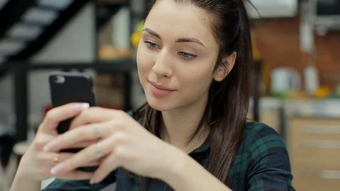 Attractive woman using smartphone in kitchen sending message on social media Video stock 73752946