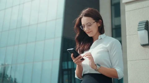 Attractive woman using smartphone while sitting near business center Stock Footage 138816150