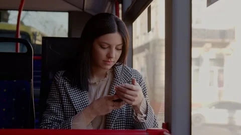 An attractive woman using a smartphone while riding a bus. Young beautiful Video stock 244511232
