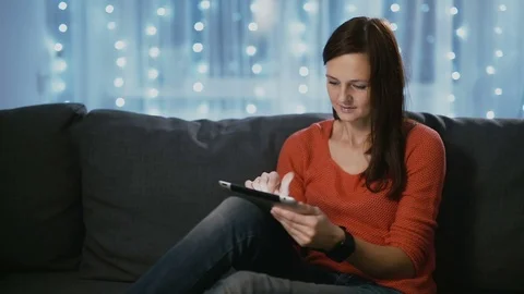 Attractive woman using a tablet computer at home on Christmas eve Medium shot Stock-Footage 70461078