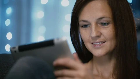 Attractive woman using a tablet computer at home on Christmas eve close-up 動画素材 70464063