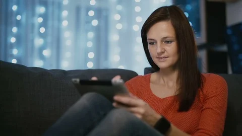 Attractive woman using a tablet pc at home on Christmas eve Medium close-up 動画素材 70462597