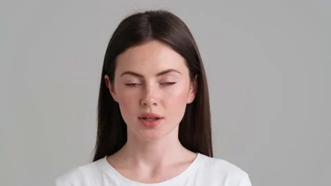 An attractive woman wearing basic T-shirt is looking to the camera Video stock 154946068