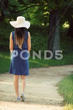 Attractive young adult woman in outdoor blue dress Stock Photos