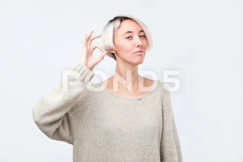 Attractive young adult woman showing ok sign. Stock Photos