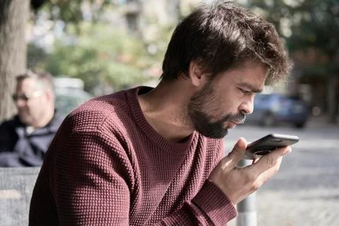 Attractive young bearded man using his smartphone in the cafe Foto stock