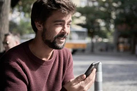 Attractive young bearded man using his smartphone in the cafe Stock Photos