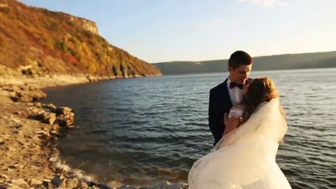 Attractive young bride hugging with her handsome husband in the picturesque Stock Footage 69150710