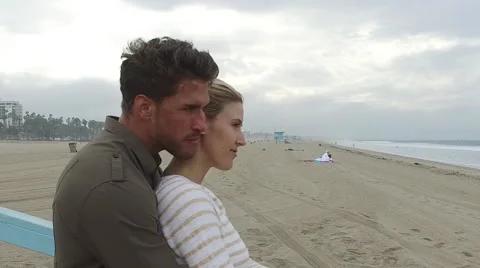 An attractive young couple embracing on the beach at sunrise. Santa Monica, Stock Footage 68050997