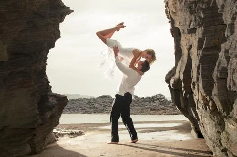 Attractive young couple guy lifting girl over his head Foto stock