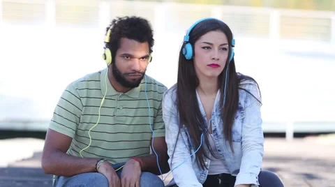 Attractive young couple listening to music with headphones Stock Footage 59555531