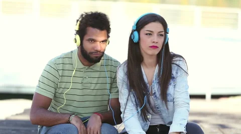 Attractive young couple listening to music with headphones Stock Footage 59555534