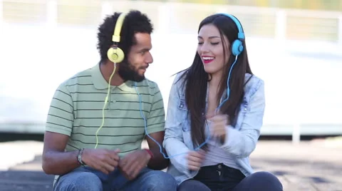 Attractive young couple listening to music with headphones and dancing Stock Footage 59555536