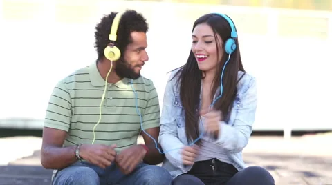 Attractive young couple listening to music with headphones and dancing Stock Footage 59555541
