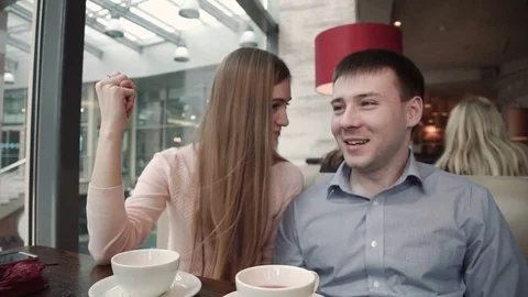 Attractive young couple using smartphone at cafe Look at the display smiling Stock Footage 74809603