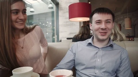 Attractive young couple using smartphone at cafe Look at the display smiling Stock Footage 74810464