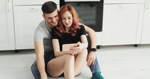 Attractive young couple using smartphone at home in kitchen Video stock 103311006