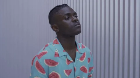 Attractive young dark skinned afro guy posing walks looking at the camera Stock Footage 110884990