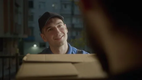 Attractive young delivery man courier in blue cap smiling Stock Footage 194508191