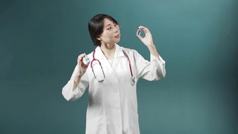 An attractive young doctor tries comparing two ampules with vaccine Stock Footage 170913810
