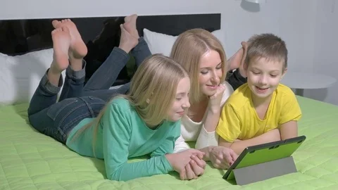 Attractive young family using a tablet in bedroom Stock Footage 71110216