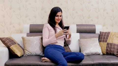 The attractive young girl happily using her touchscreen mobile phone - leisur... Stock Photos