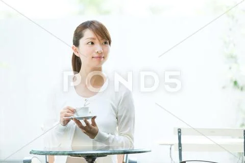 Attractive young girl having coffee outside Stock Photos