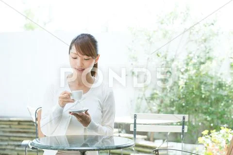 Attractive young girl having coffee outside Stock Photos