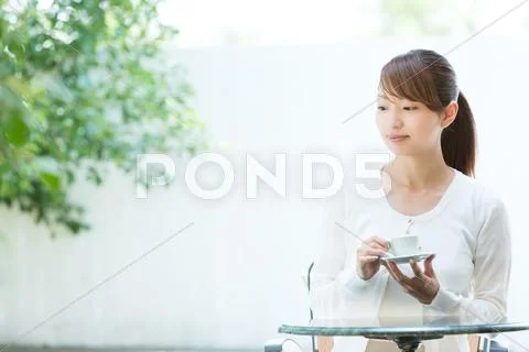 Attractive young girl having coffee outside Stock Photos