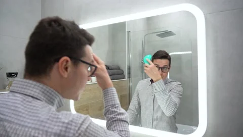 Attractive young guy doing modern hairstyle. Morning routine and ready for work. Stock Footage 131465147