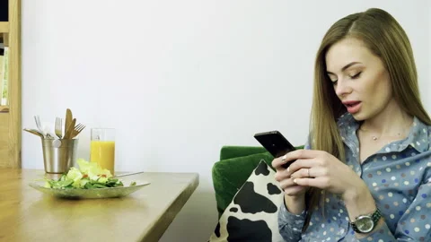 Attractive young happy woman using mobile phone during resting in a cafe. 4K Stock Footage 102732053
