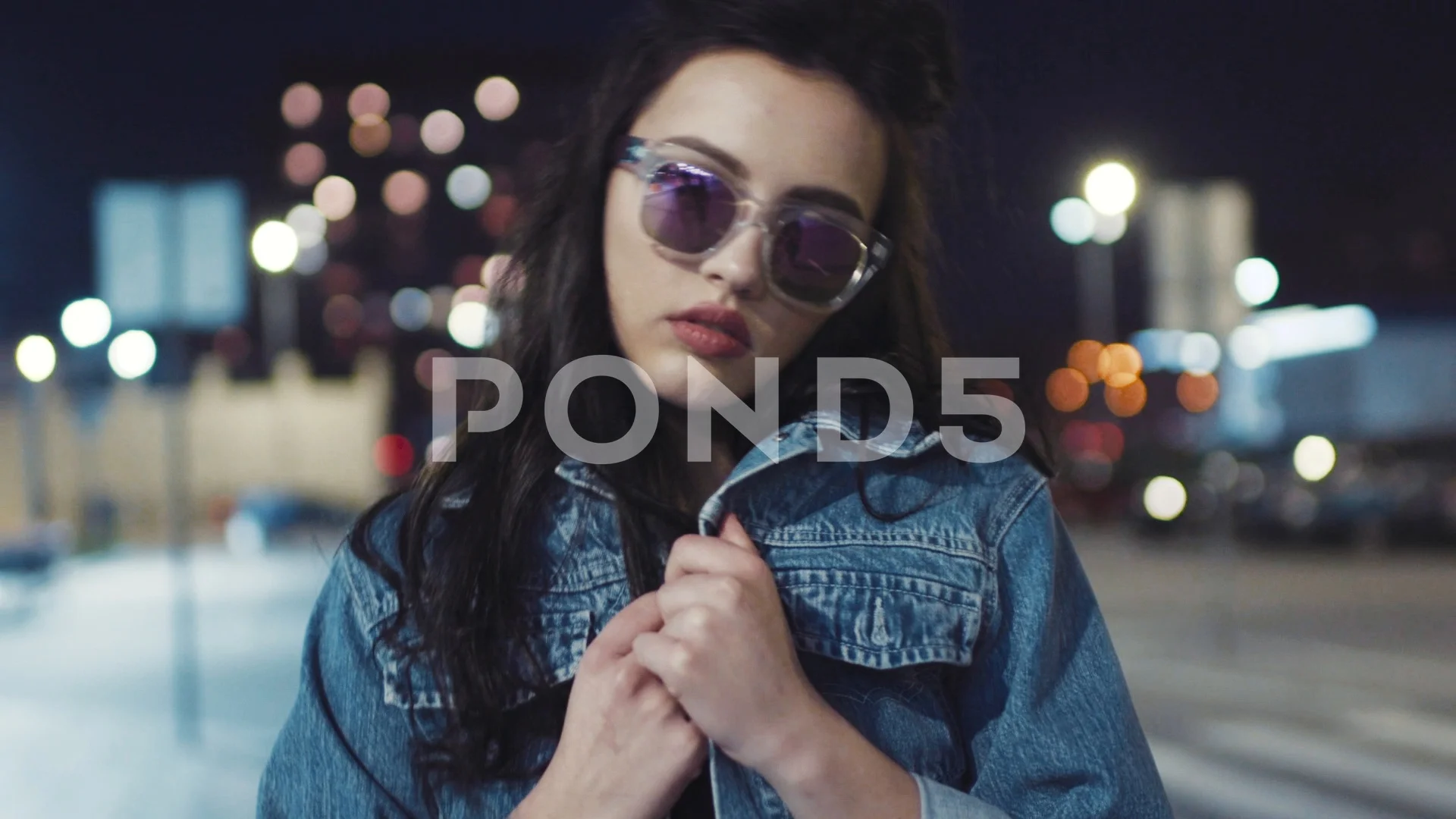 Attractive young hot brunette girl in jeans jacket and stylish sunglasses  poses