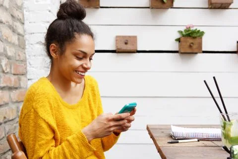 Attractive young lady using cellphone at cafe Stock Photos
