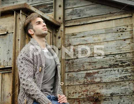 Attractive young man against rusty metal and wooden walls Stock Photos