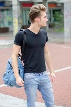 Attractive young man with backpack standing outside Stock Photos