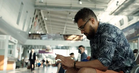 Attractive young man with a beard in stylish clothes in yellow glasses sits at Stock Footage 127464320