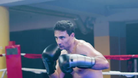 Attractive young man doing shadow fight in boxing ring Stock Footage 181836896