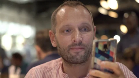 Attractive, young man drinking beer and using smartphone in cafe Video stock 74738347