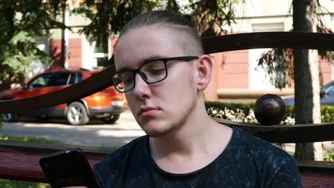 Attractive Young Man with Glasses Using a Smartphone Stock Footage 114801546