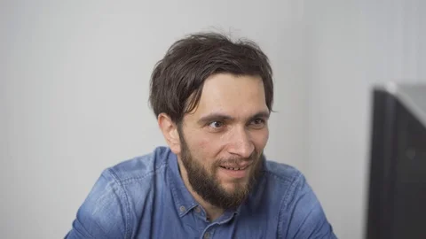 Attractive young man having video chat using webcam at home chatting to friend Stock Footage 115034428