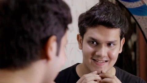 Attractive young man looking at himself in a mirror while standing in the bat... Stock Footage 156590469