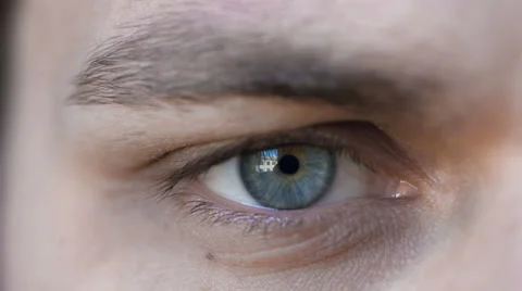 Attractive young man looks into the camera: beautiful expressive blue eye Stock Footage 39383191