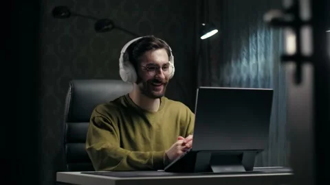 Attractive young man make video call using laptop sitting at home.Man wearing Stock Footage 232132351