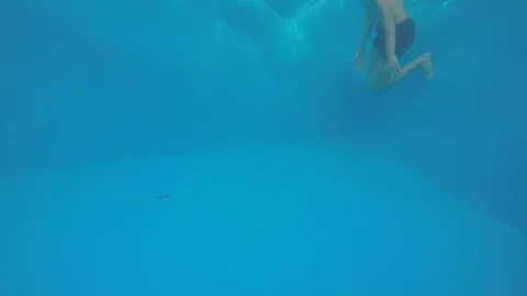 Attractive young man playing in a pool in summer 動画素材 106309892