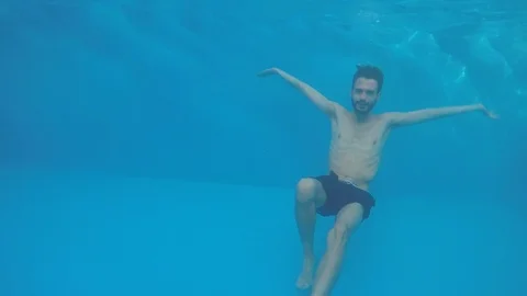 Attractive young man playing in a pool in summer Vidéo 106309905
